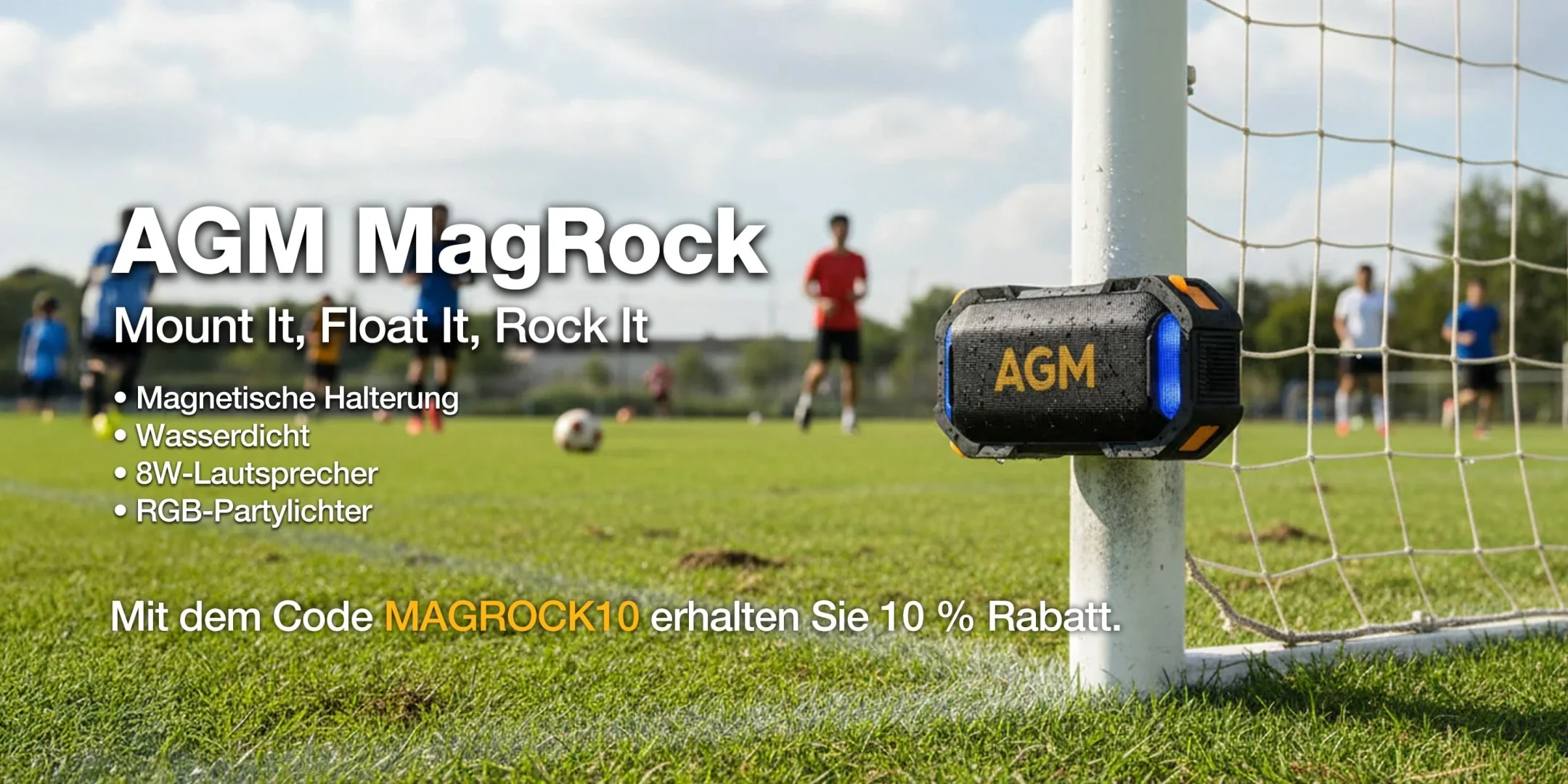 AGM MagRock Bluetooth-Lautsprecher magnetisch an einem Torpfosten befestigt, mit einem Fussballplatz im Hintergrund.