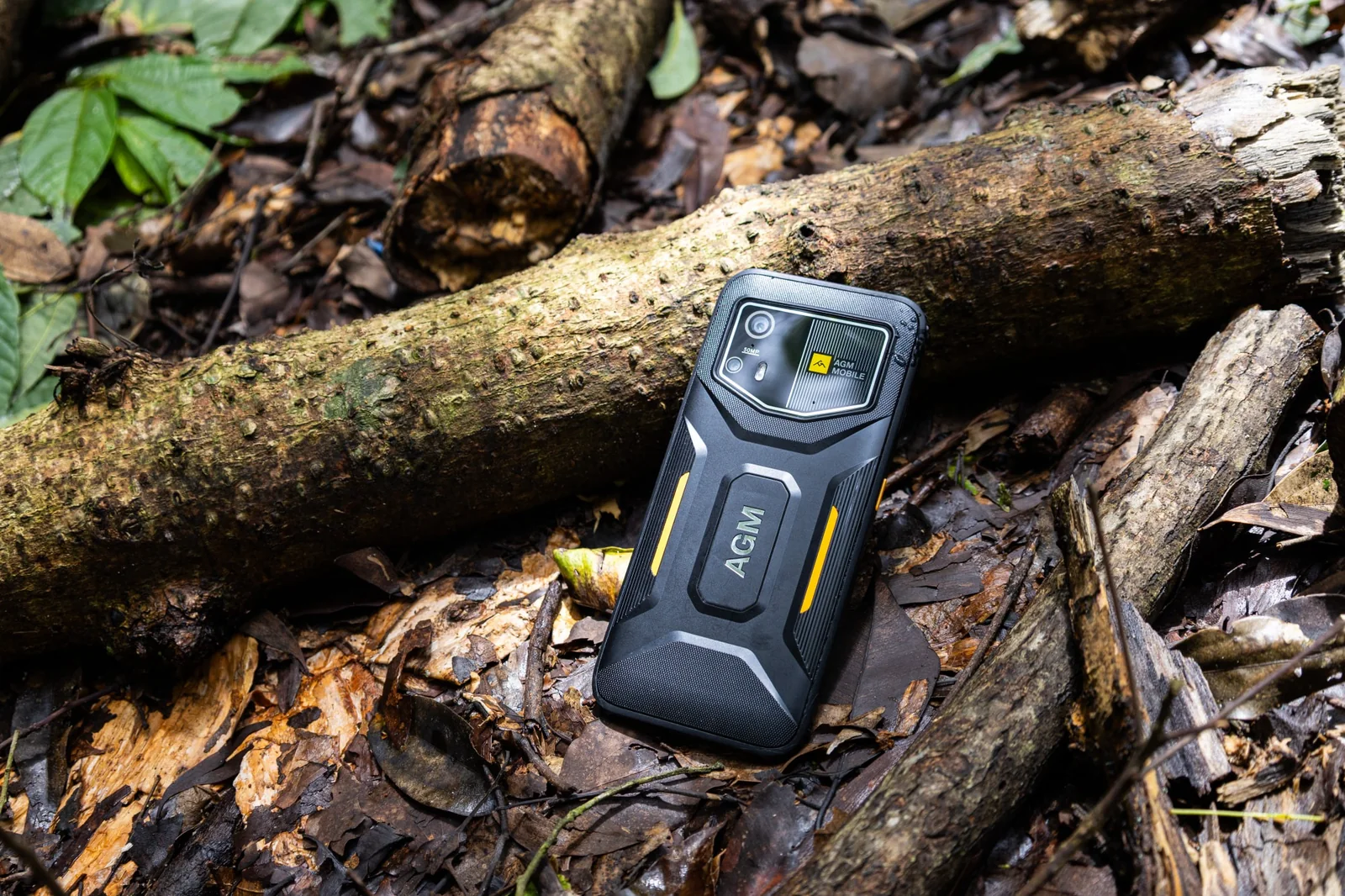 AGM H6 Pro mit sichtbarer Rückseite auf dem Waldboden vor einem Baumstamm